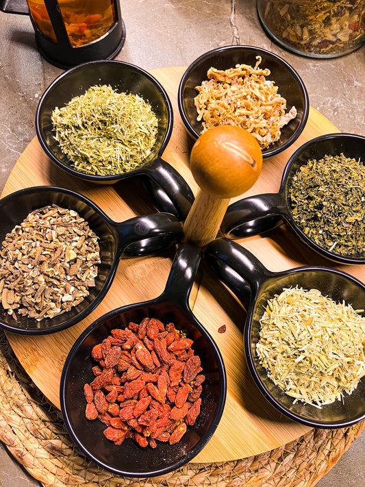 a display of nutrient-rich herbs including irish sea moss, nettles, oat straw, dandelion root, horsetail, and goji berries